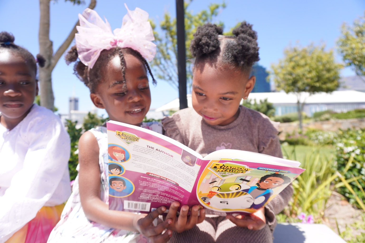 Children gathered outdoors with sponsored copies held high.